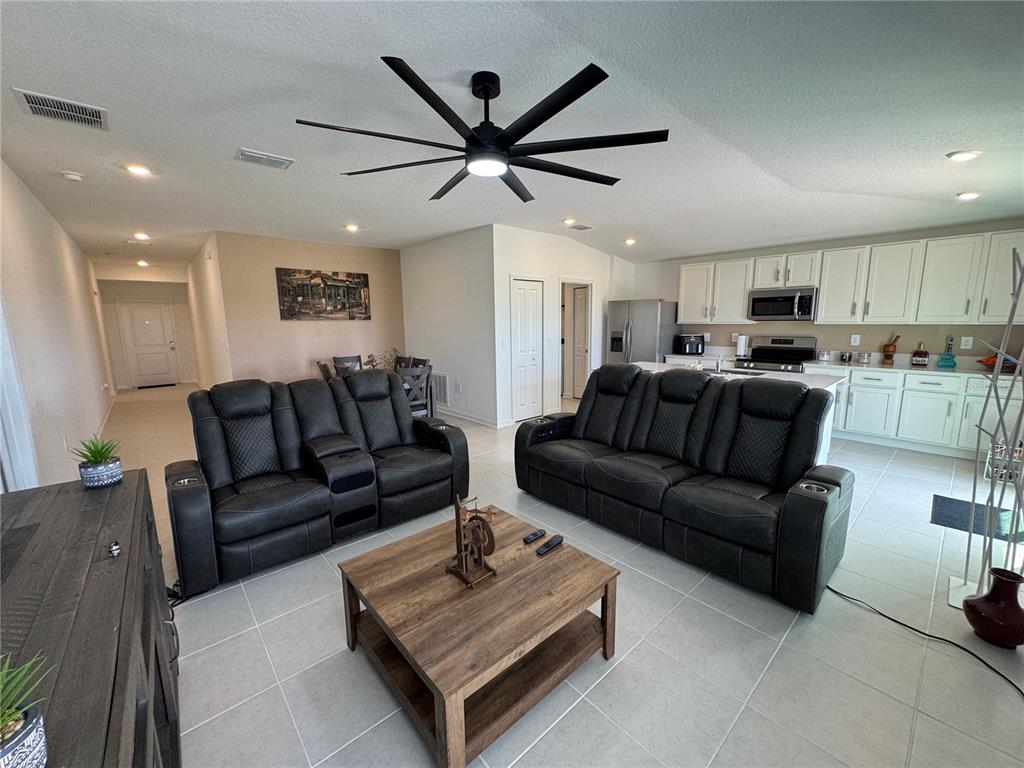 2405 Bluestone Road Haines City, FL 33844 - Photo 6 of 17 a living room with furniture a ceiling fan and a window