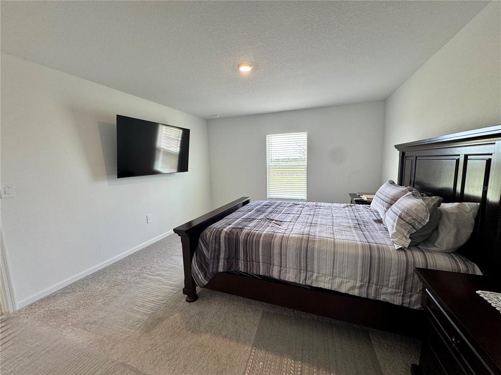 2405 Bluestone Road Haines City, FL 33844 - Photo 10 of 17 a bedroom with a bed and a flat screen tv