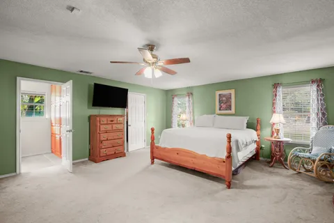 a bedroom with a bed a chandelier and a window