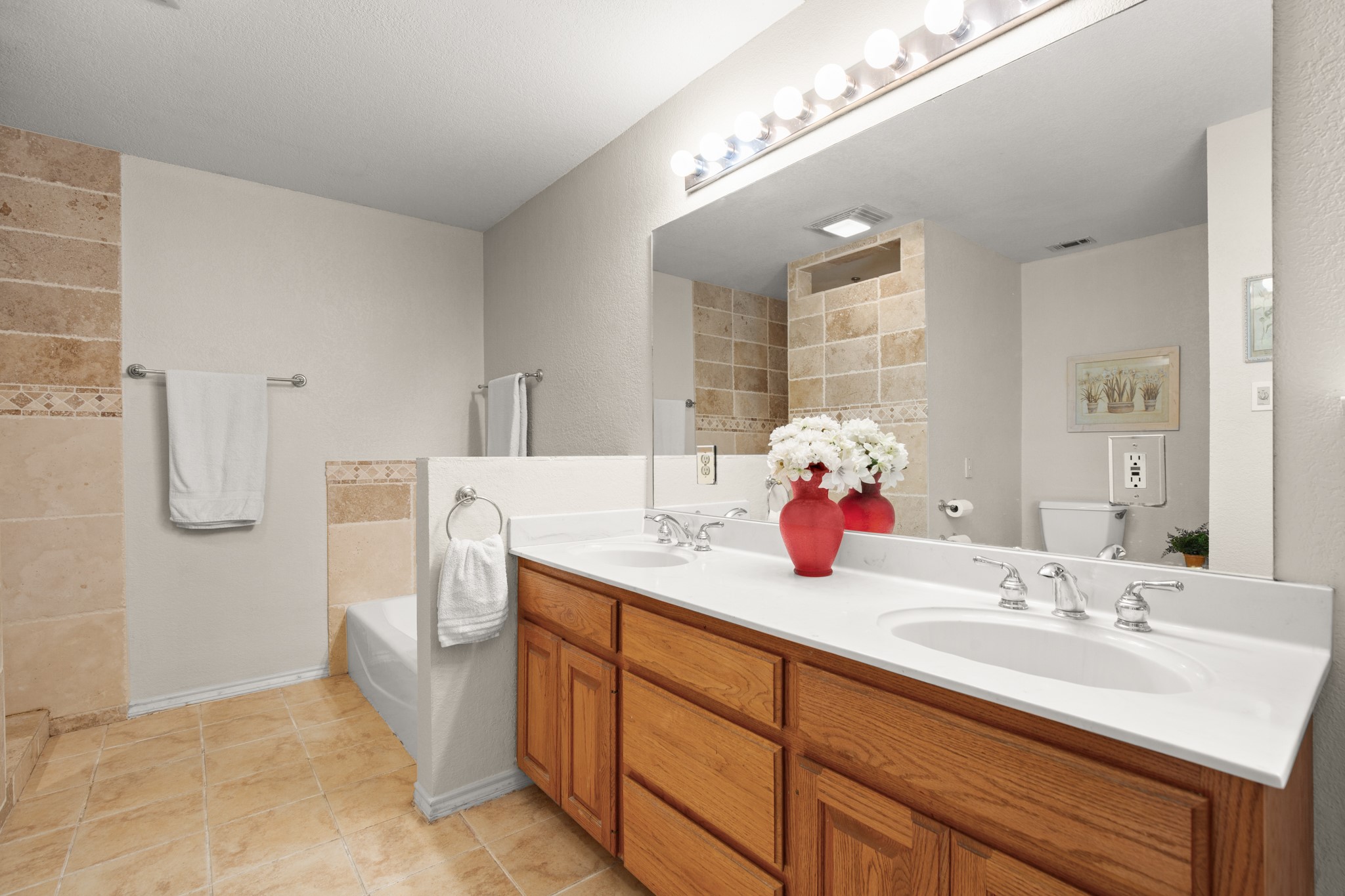 350 Lost River Road Georgetown, TX 78628 - Photo 19 of 39 Your ensuite has so much storage space. You have a soaking tub, an updated walk-in shower with a seat, a double vanity, and a walk-in closet.