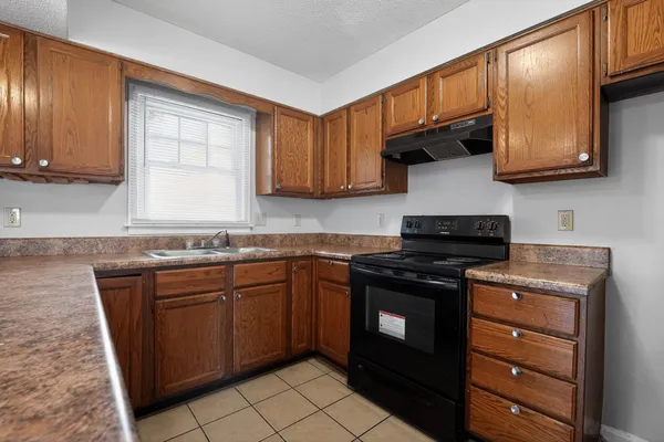 a kitchen with stainless steel appliances granite countertop a stove a sink dishwasher and a microwave oven with cabinets