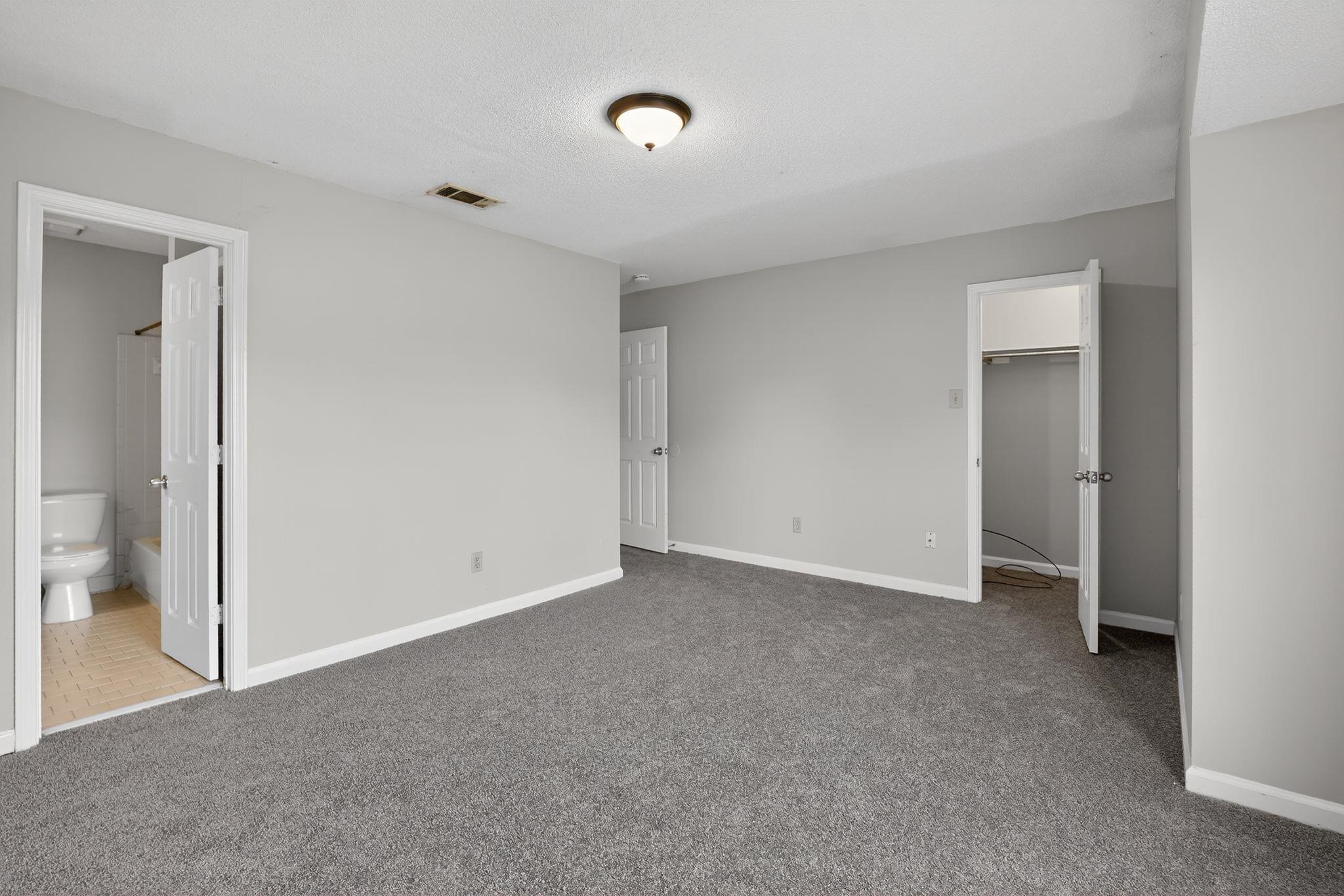 5581 Crepe Myrtle Drive Memphis, TN 38115 - Photo 21 of 33 Unfurnished bedroom with a spacious closet, light colored carpet, and ensuite bath