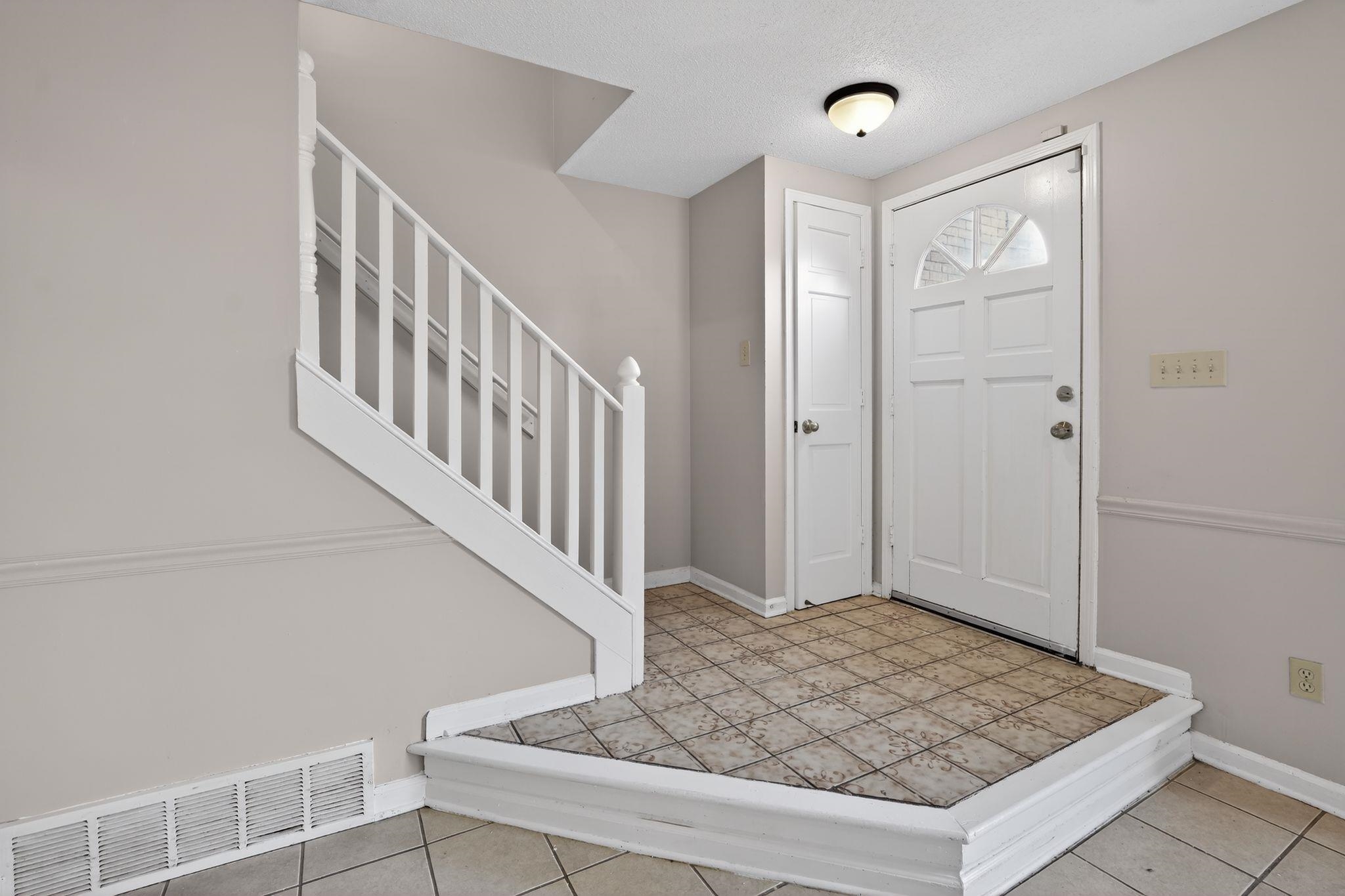 5581 Crepe Myrtle Drive Memphis, TN 38115 - Photo 8 of 33 Foyer featuring stairs, a textured ceiling, and light tile patterned floors