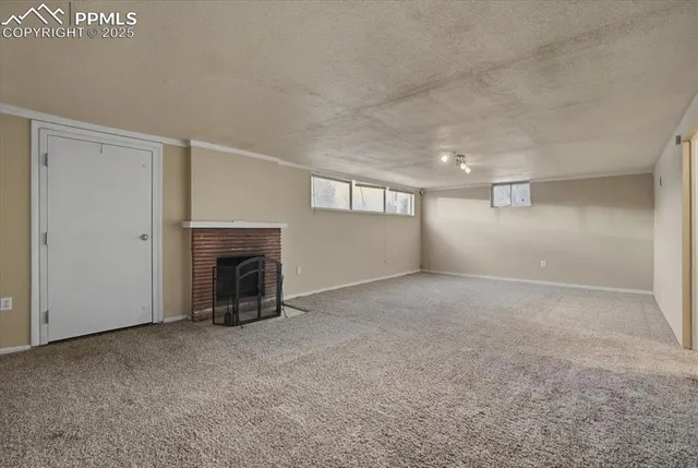 a view of an empty room with a fireplace and a window