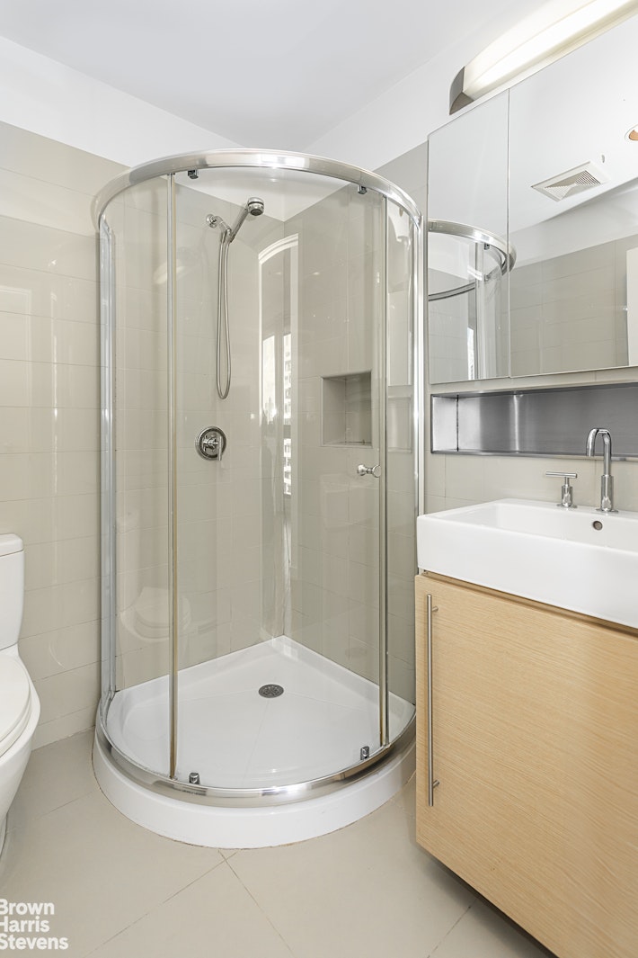 38 Delancey Street, Unit 10D Manhattan, NY 10002 - Photo 8 of 14 a bathroom with a shower and a sink