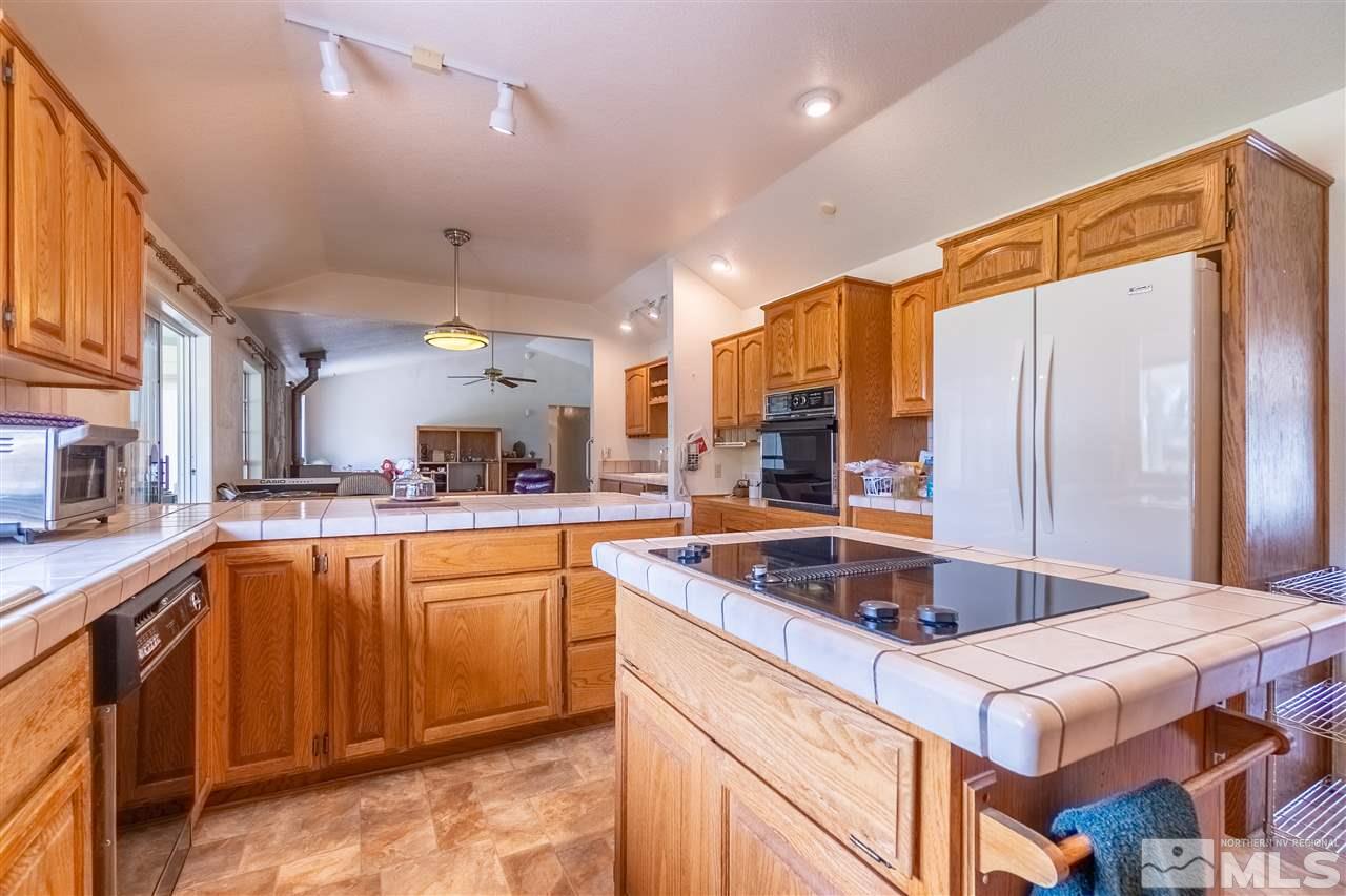 761 Rubio Way Gardnerville, NV 89460 - Photo 13 of 30 a kitchen with stainless steel appliances granite countertop a sink a stove and a refrigerator