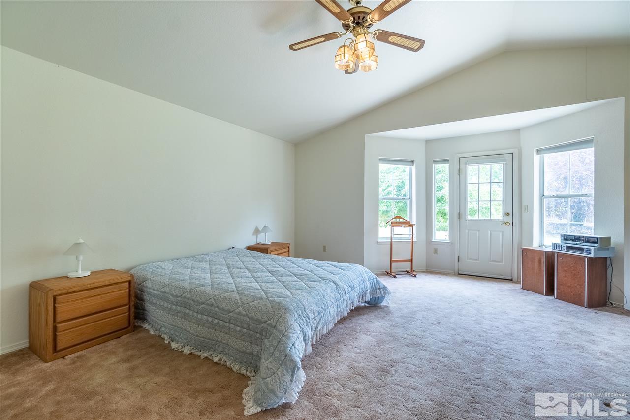 761 Rubio Way Gardnerville, NV 89460 - Photo 22 of 30 a spacious bedroom with a bed and a chandelier