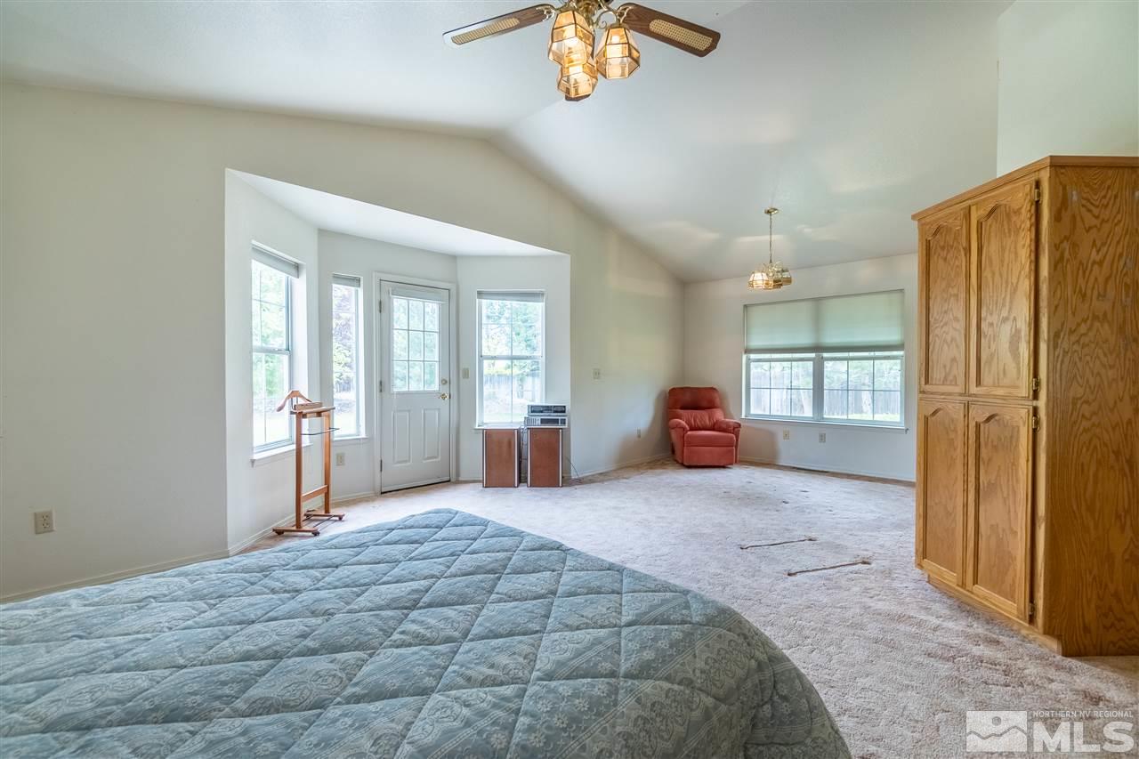 761 Rubio Way Gardnerville, NV 89460 - Photo 23 of 30 a large bedroom with a large bed and chandelier fan