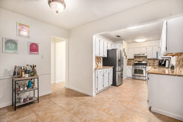 a kitchen with stainless steel appliances granite countertop a refrigerator and a sink