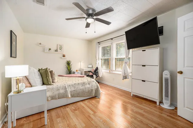 a bedroom with a bed and wooden floor