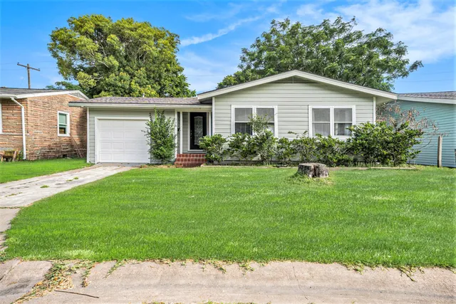 a view of a house with backyard and a garden