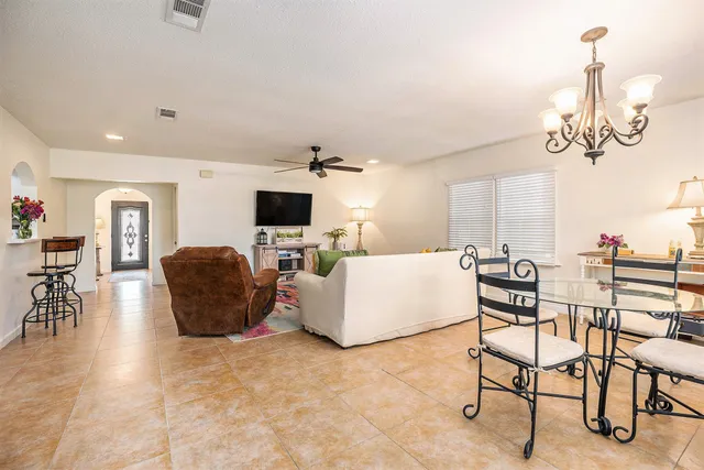 a living room with couches a flat screen tv and kitchen view
