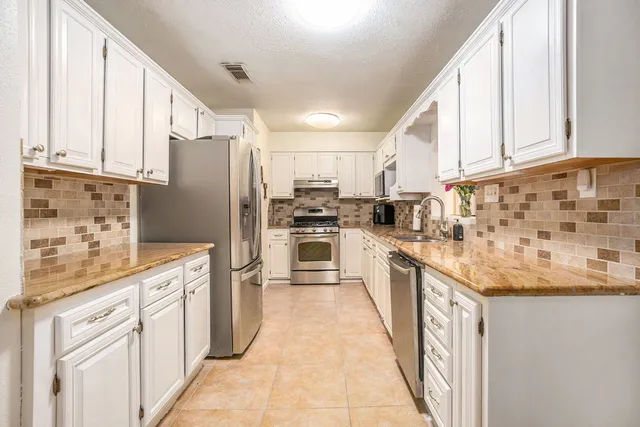 a kitchen with stainless steel appliances granite countertop a refrigerator sink and cabinets