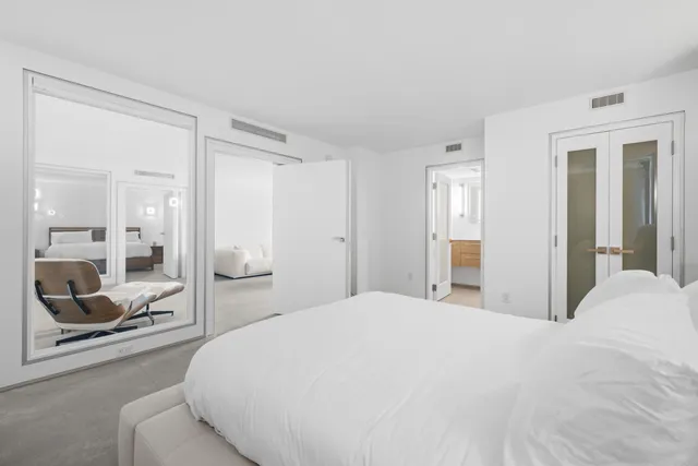 a spacious bedroom with a bed and a large mirror