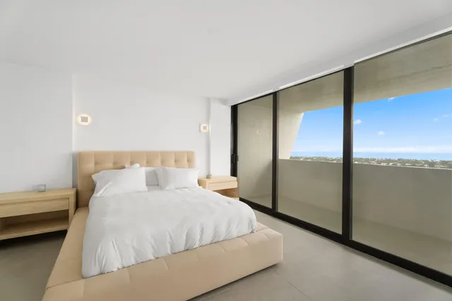 a bedroom with a large bed and a large window