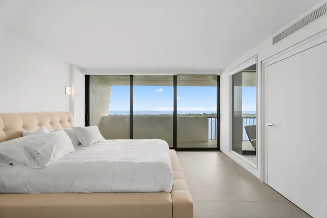 a large bed sitting in a bedroom next to a window