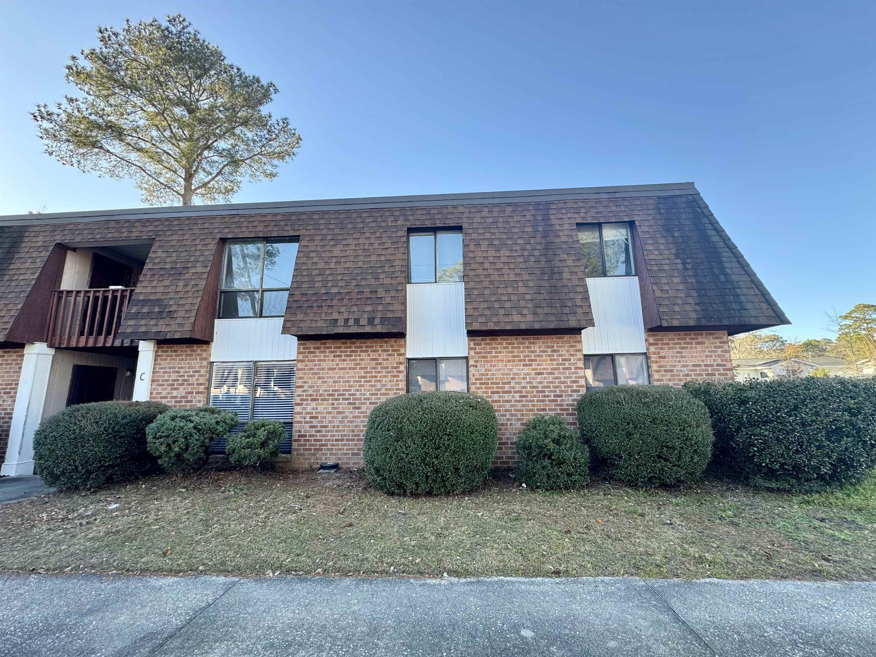 615 Carter Lane, Unit C2 Conway, SC 29526 - Photo 2 of 9 View of side of home with mansard roof, brick siding, a balcony, and roof with shingles