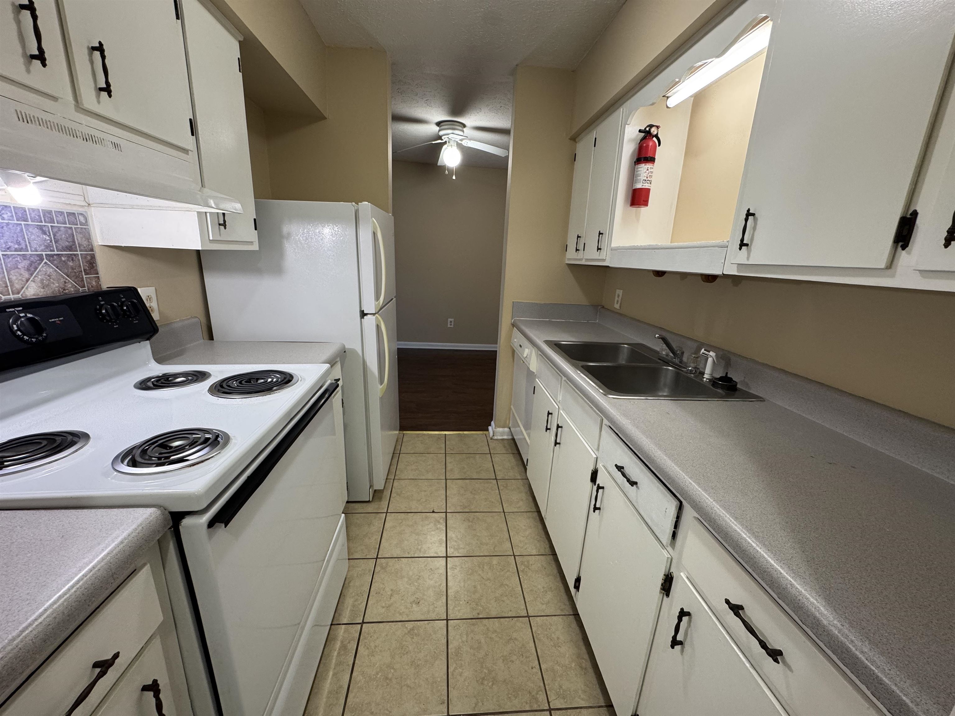 615 Carter Lane, Unit C2 Conway, SC 29526 - Photo 5 of 9 Kitchen featuring white appliances, white cabinetry, under cabinet range hood, light countertops, and a ceiling fan