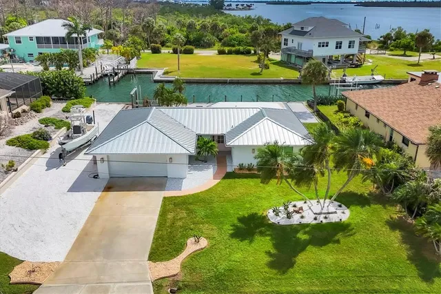 an aerial view of a house with swimming pool patio and lake view