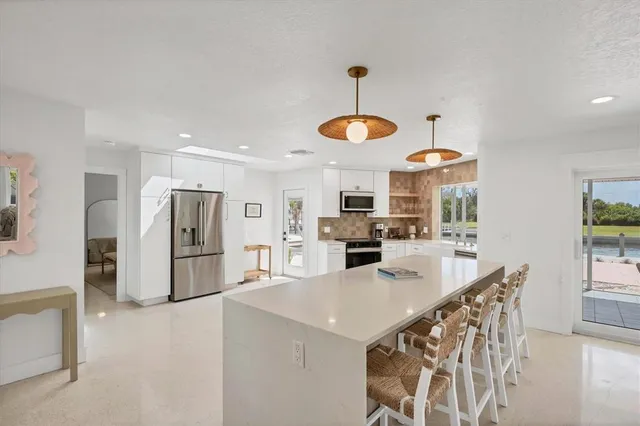 a large white kitchen with stainless steel appliances