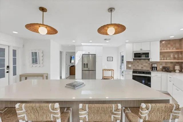 a kitchen with white cabinets and white appliances