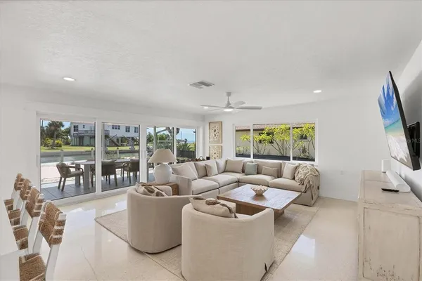 a kitchen with stainless steel appliances granite countertop a sink a stove a refrigerator a microwave a dining table and chairs with wooden floor