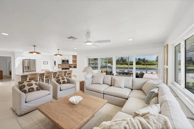 a large kitchen with stainless steel appliances granite countertop a stove a refrigerator a oven a sink with a dining table and chairs