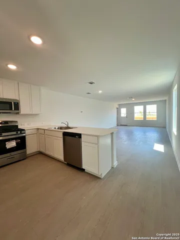 a kitchen with white cabinets stainless steel appliances and sink