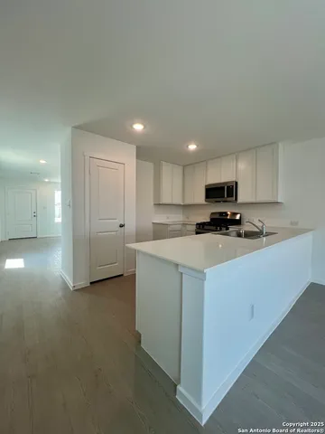 a kitchen with stainless steel appliances granite countertop a stove a sink and a microwave