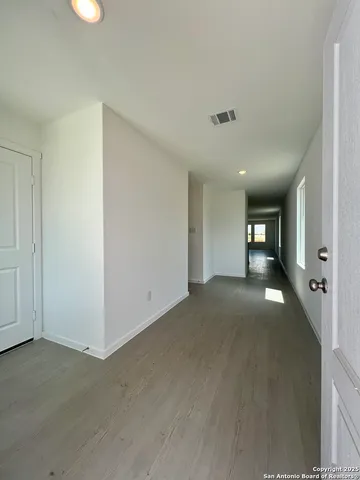 a view of empty room with wooden floor
