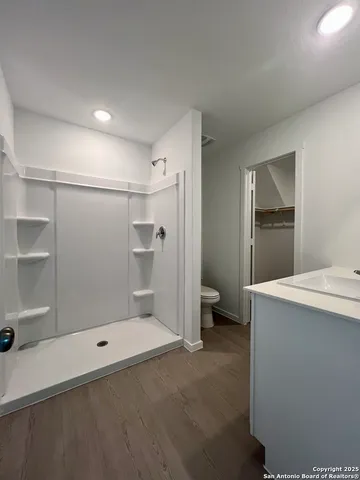 a white toilet sitting next to a shower