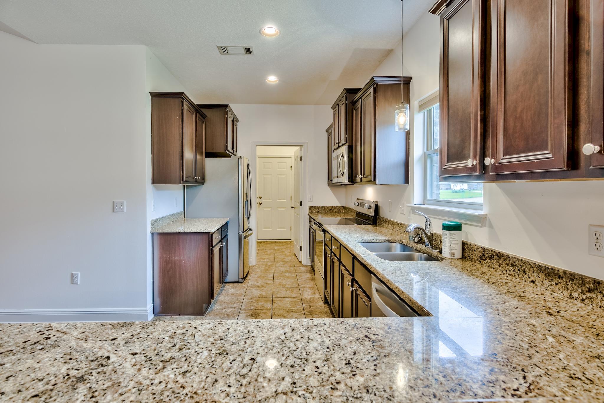 70 Riverbirch Loop Santa Rosa Beach, FL 32459 - Photo 7 of 45 a kitchen with stainless steel appliances granite countertop a refrigerator a stove and a sink with wooden floor