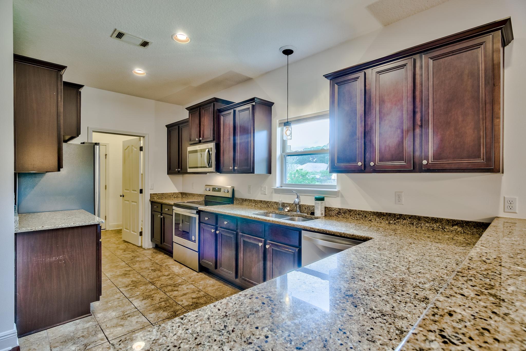 70 Riverbirch Loop Santa Rosa Beach, FL 32459 - Photo 8 of 45 a kitchen with stainless steel appliances granite countertop wooden cabinets a refrigerator and a sink