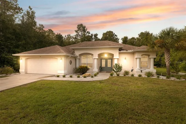 a front view of a house with a garden and yard