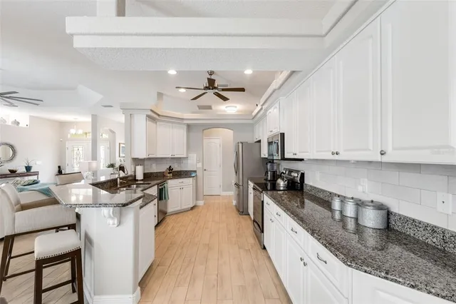 a dining room with furniture a chandelier and wooden floor