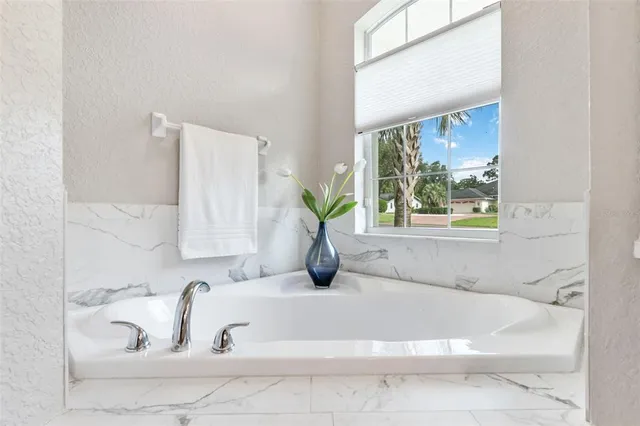 a dining room with wooden floor a chandelier fan windows and a chandelier