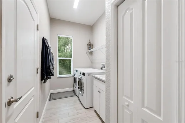 a aerial view of a house next to a big yard with plants and large trees