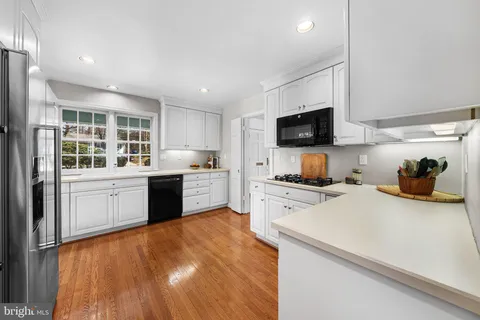 a kitchen with a refrigerator wooden floor and a sink