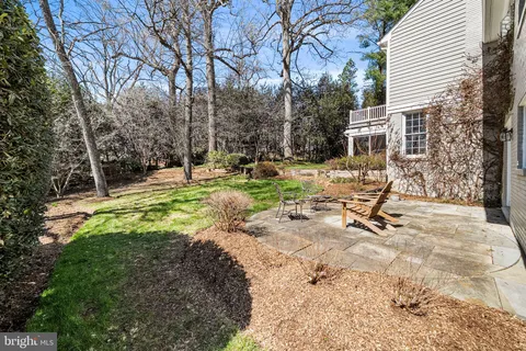 a spacious bedroom with a bed a table and a chandelier