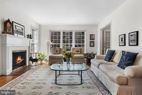a living room with furniture a fireplace and a floor to ceiling window