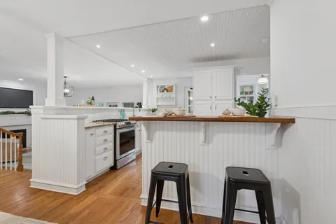 a kitchen with white cabinets stainless steel appliances and a dining table