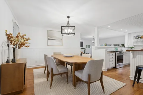 a view of a dining room with furniture and a chandelier