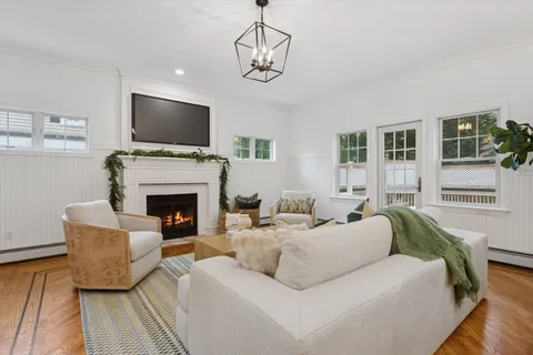 a living room with furniture a flat screen tv and a fireplace