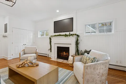 a living room with furniture a flat screen tv and a fireplace