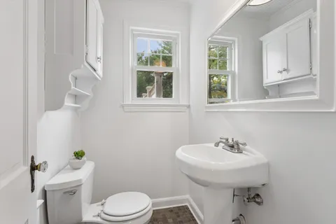 a bathroom with a sink a toilet and a mirror