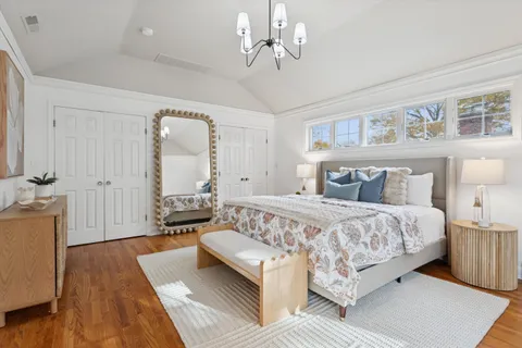 a bedroom with a large bed and a chandelier