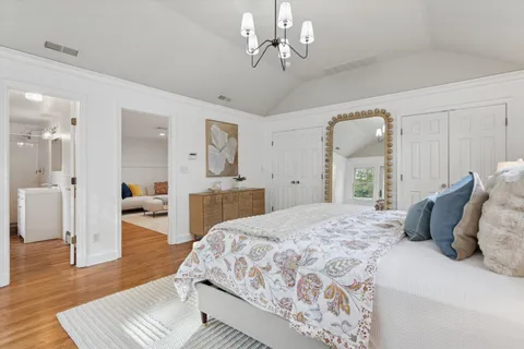 a bedroom with a large bed and a chandelier