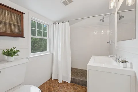 a bathroom with a sink toilet and shower