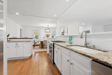 a large kitchen with a lot of counter space and wooden floor