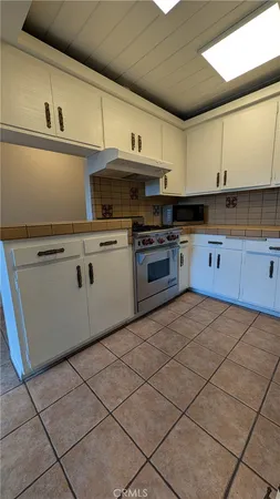 a kitchen with stainless steel appliances granite countertop a sink a stove a microwave and cabinets